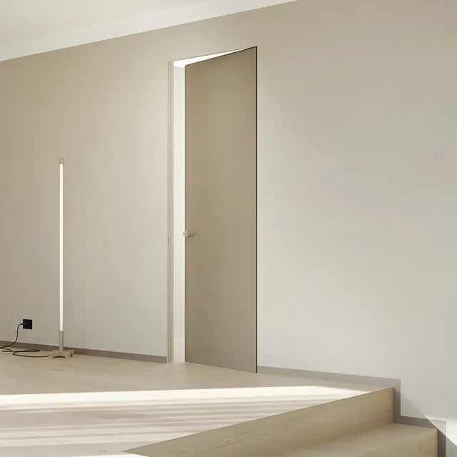 Porta battente filo muro elegante, perfettamente integrata nella parete, ideale per un design minimal moderno. Porta di colore beige.