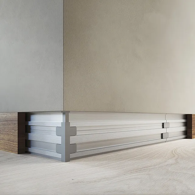 Battiscopa filo muro dallo stile minimalista, integrato perfettamente nella parete per un effetto uniforme e raffinato. Colore legno caldo su muro di colore tortora. L'immagine mostra l'angolo delle pareti.